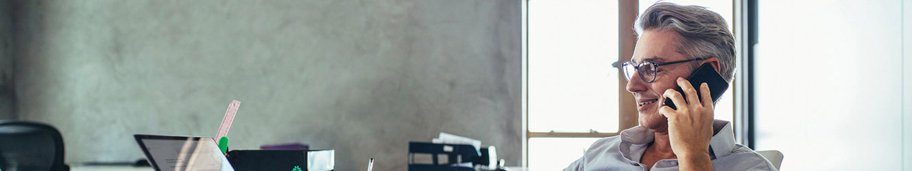 Man talking on phone while using computer