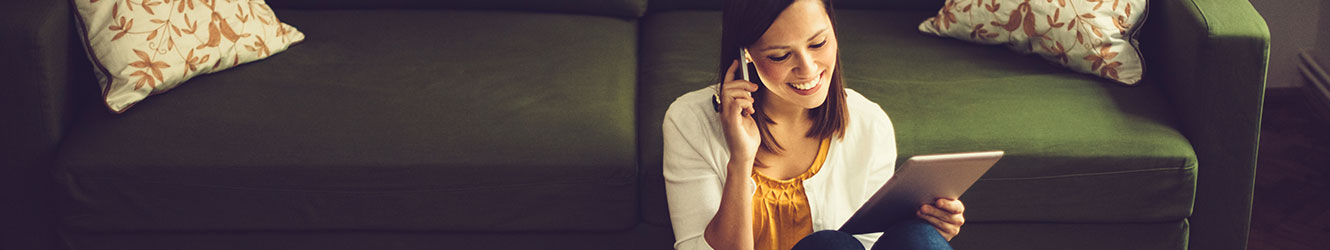 Woman using tablet while talking on phone